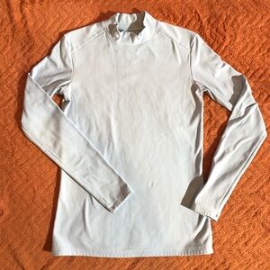 Women’s medium long sleeve light blue Under Armour athletic shirt high collar.